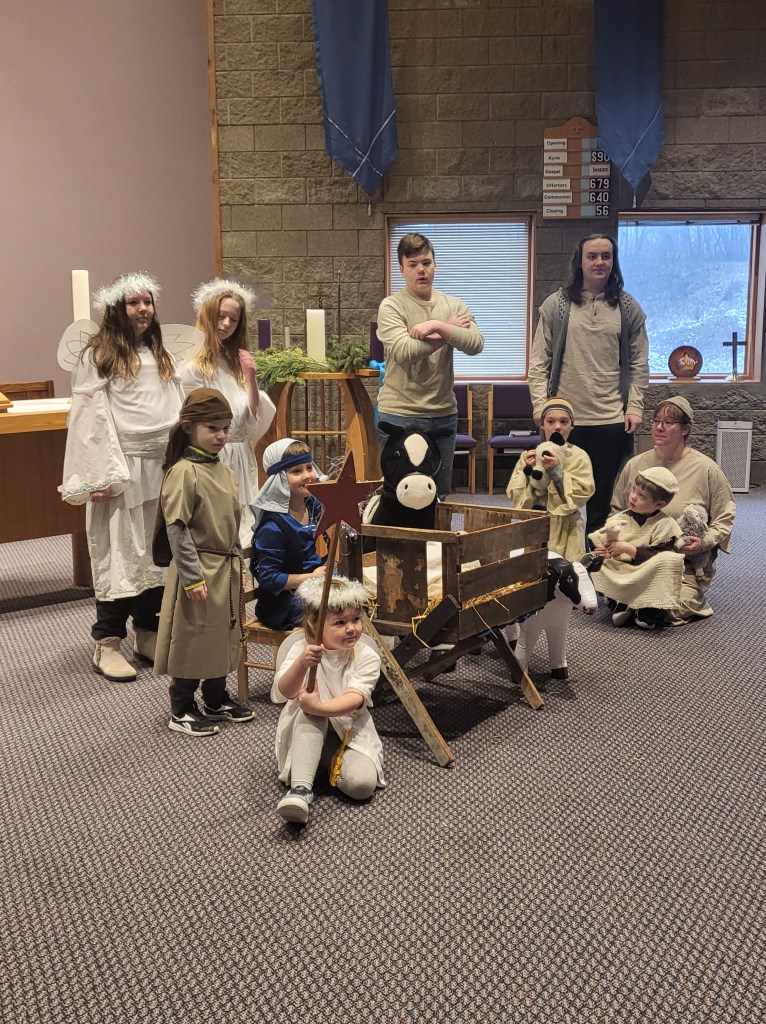 Children's Christmas pageant in the Sanctuary. The stage is set with the manger and it's animals.