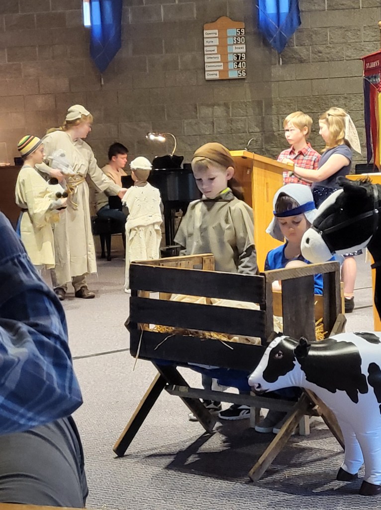 Children's Christmas pageant in the sanctuary. The stage is set with the manger and it's animals.